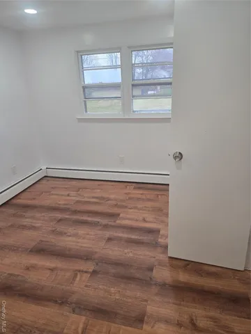 a view of an empty room with wooden floor