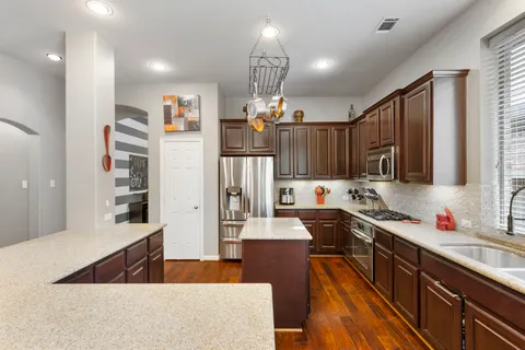a kitchen with granite countertop a sink stove and refrigerator
