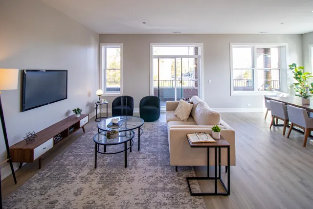 a living room with furniture a window and a flat screen tv