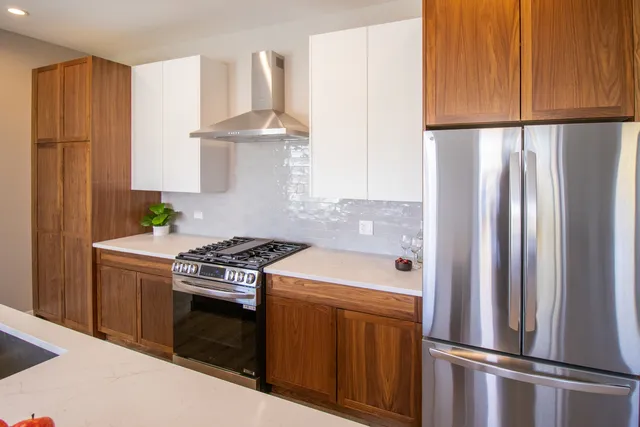 a kitchen with stainless steel appliances granite countertop a refrigerator a stove and a refrigerator