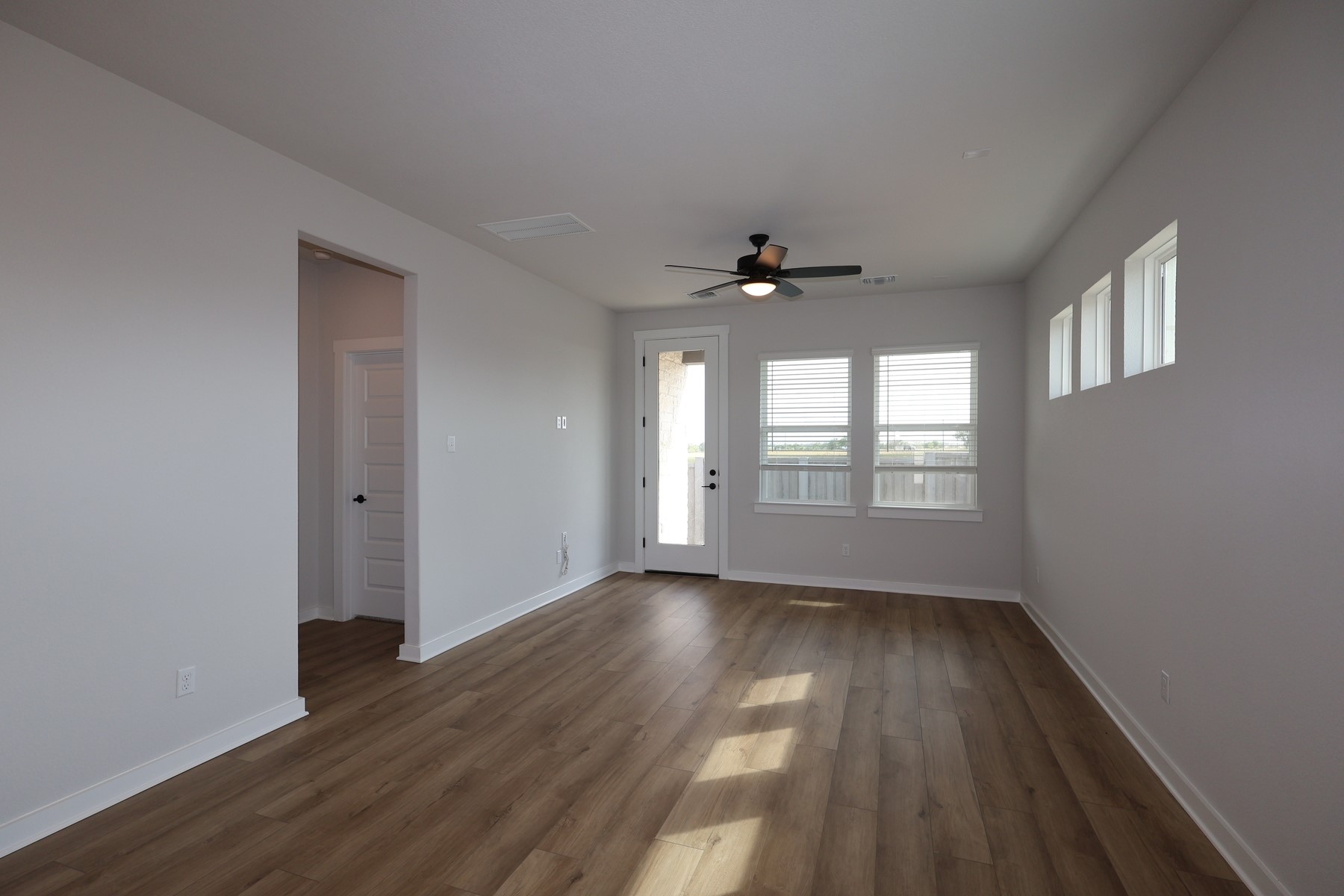 304 Emerie Way Georgetown, TX 78626 - Photo 4 of 15 a view of an empty room with wooden floor and a window