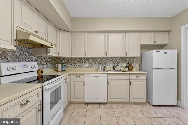 a kitchen with appliances a sink and cabinets