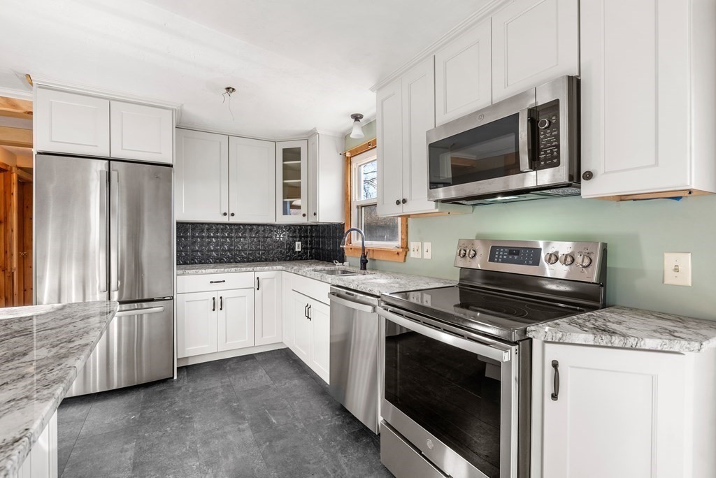 4 Meadow Lane Three Rivers, MA 01080 - Photo 3 of 23 a kitchen with granite countertop white cabinets sink and stainless steel appliances