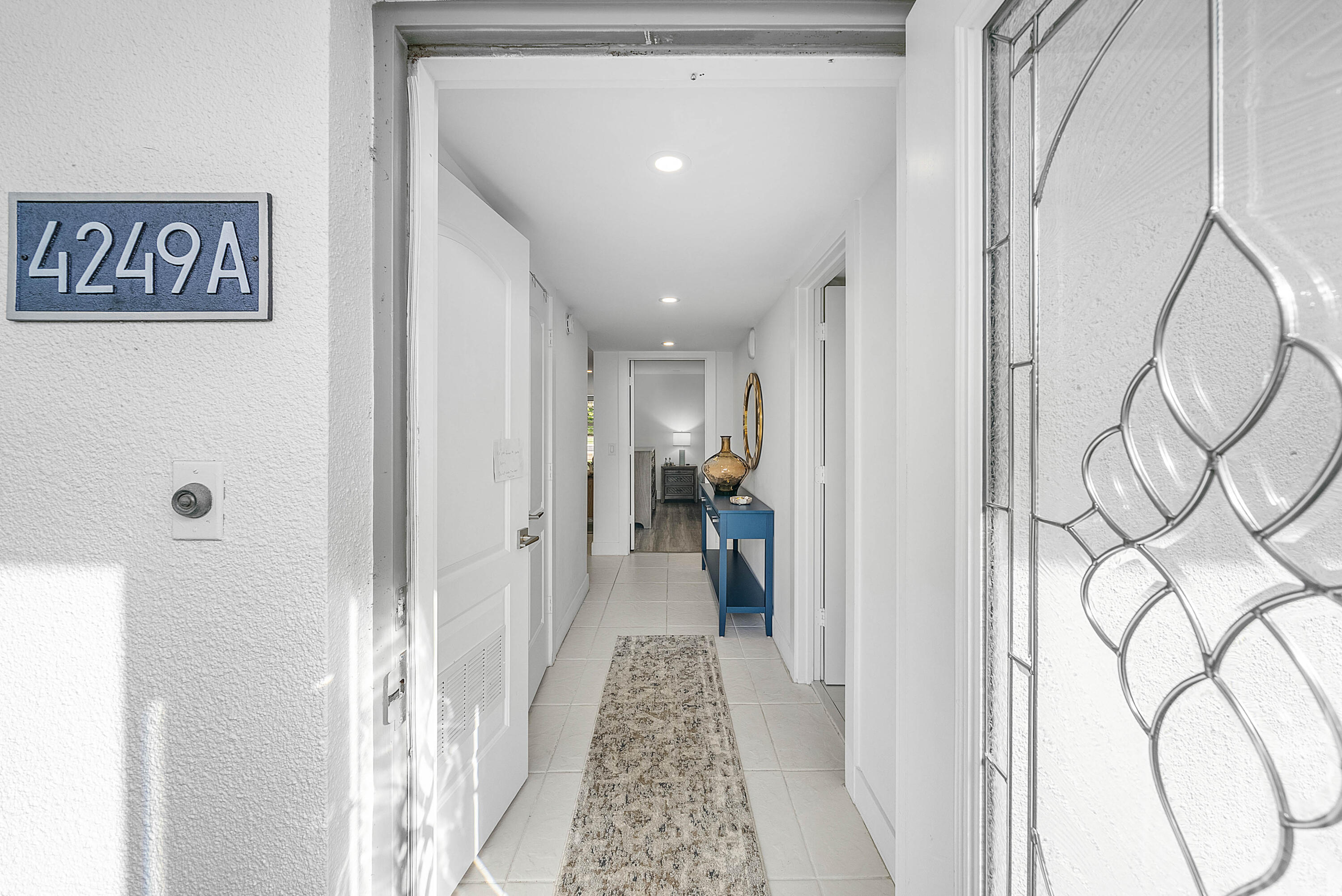 4249 North Quail Ridge Drive, Unit A Boynton Beach, FL 33436 - Photo 2 of 49 a view of a hallway with wooden floor and entryway