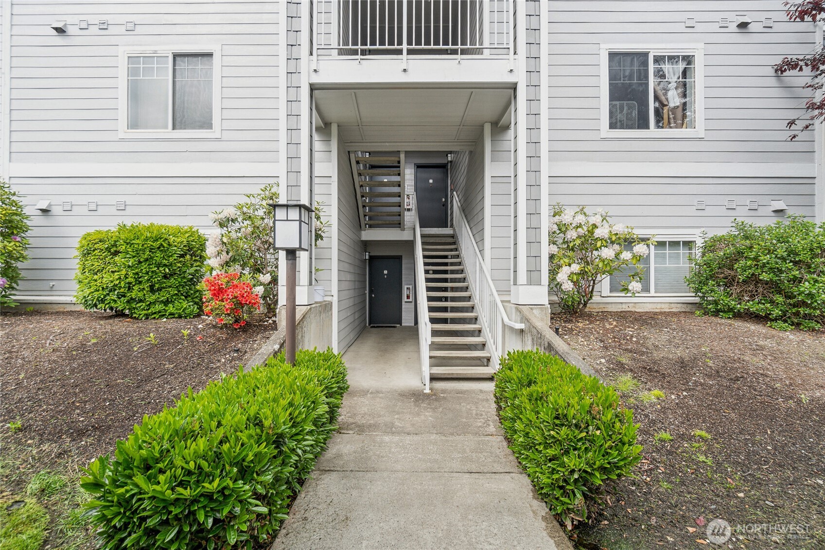 15150 140th Way Southeast, Unit T304 Renton, WA 98058 - Photo 2 of 30 a front view of a house with a yard and flowers
