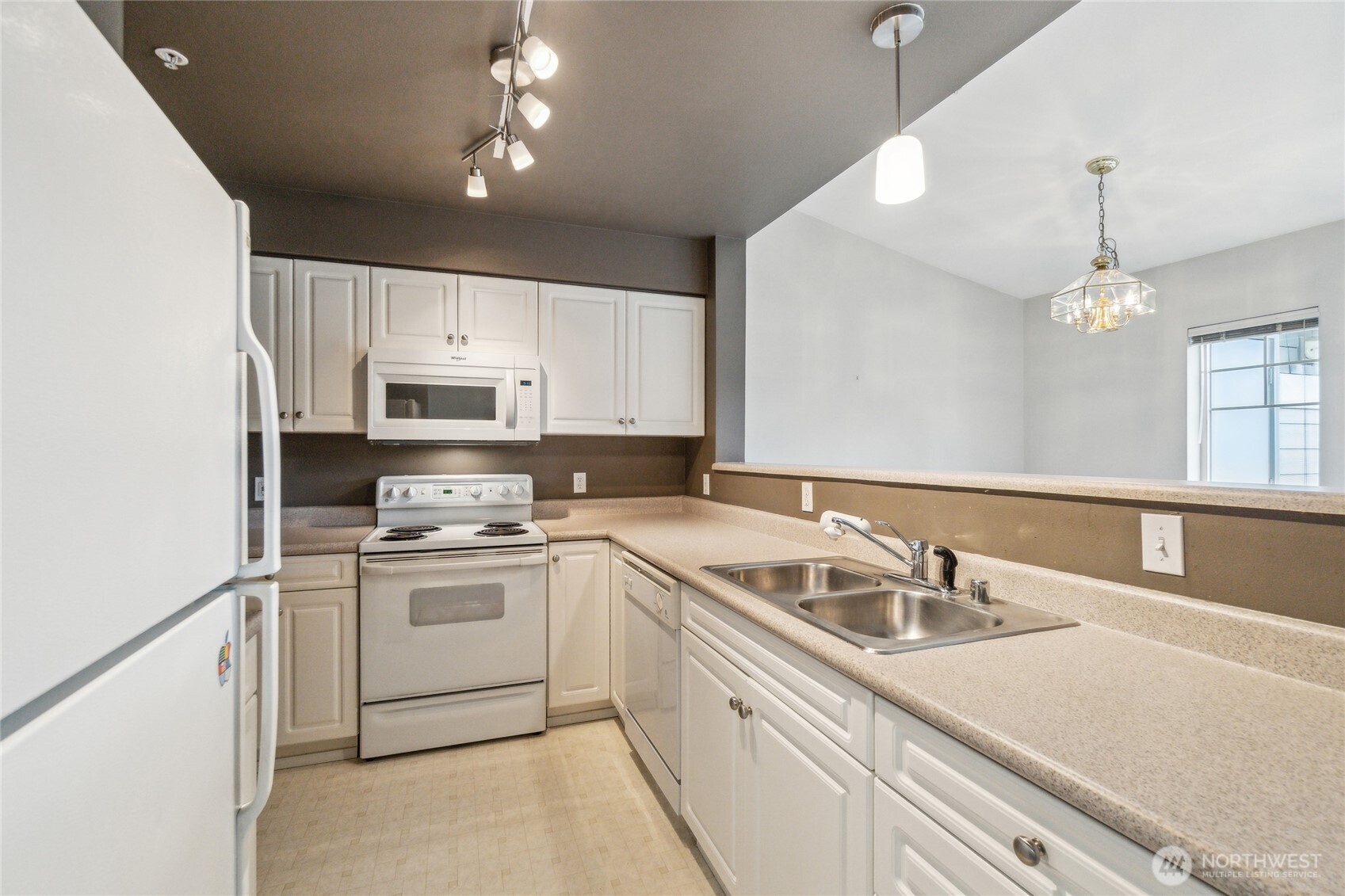 15150 140th Way Southeast, Unit T304 Renton, WA 98058 - Photo 10 of 30 a kitchen with kitchen island granite countertop a sink white cabinets stove and refrigerator