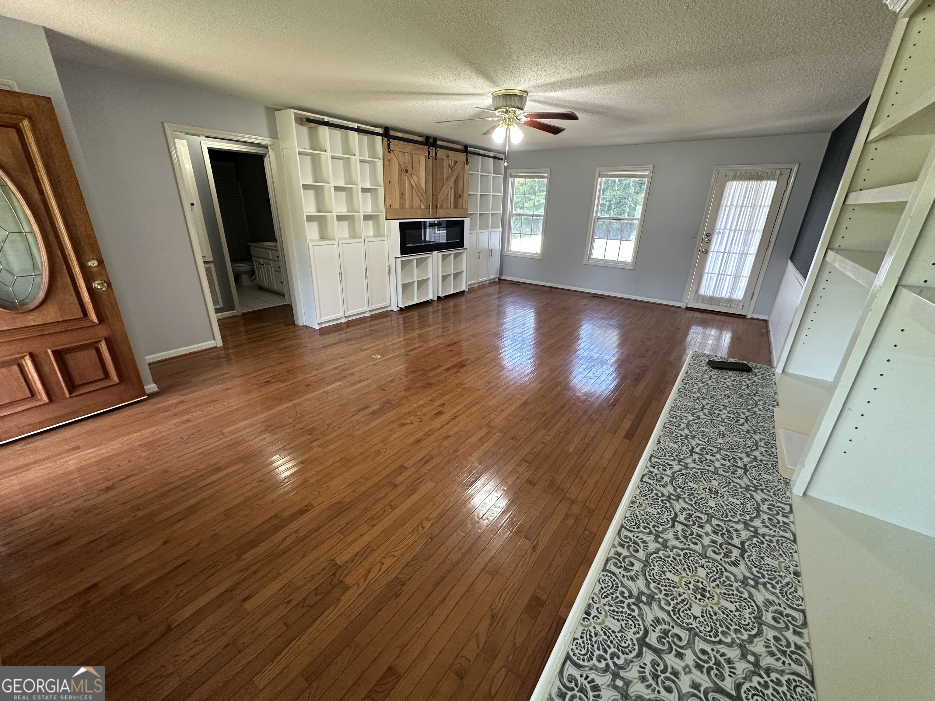 384 Sam Brown Boulevard Commerce, GA 30529 - Photo 8 of 25 wooden floor with windows and fireplace in a room