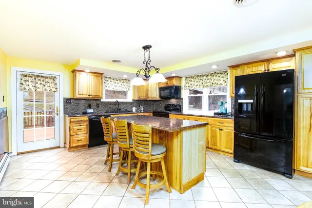 a kitchen with granite countertop a refrigerator and a stove top oven