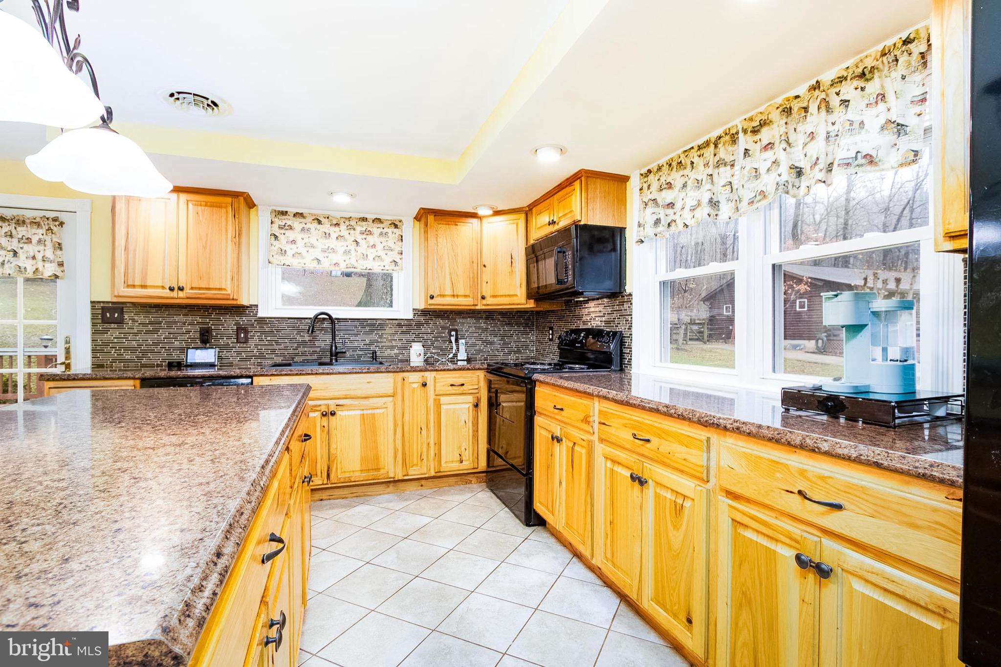 355 Silver Run Valley Road Westminster, MD 21158 - Photo 4 of 49 a large kitchen with kitchen island granite countertop a large window and a counter space