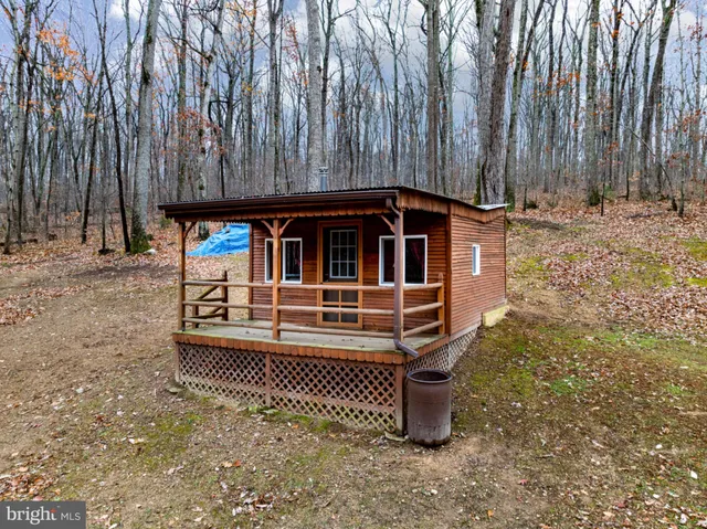 a view of a house with wooden deck and furniture