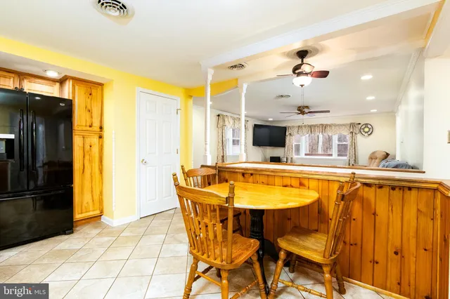 a dining room with stainless steel appliances kitchen island granite countertop a table and chairs