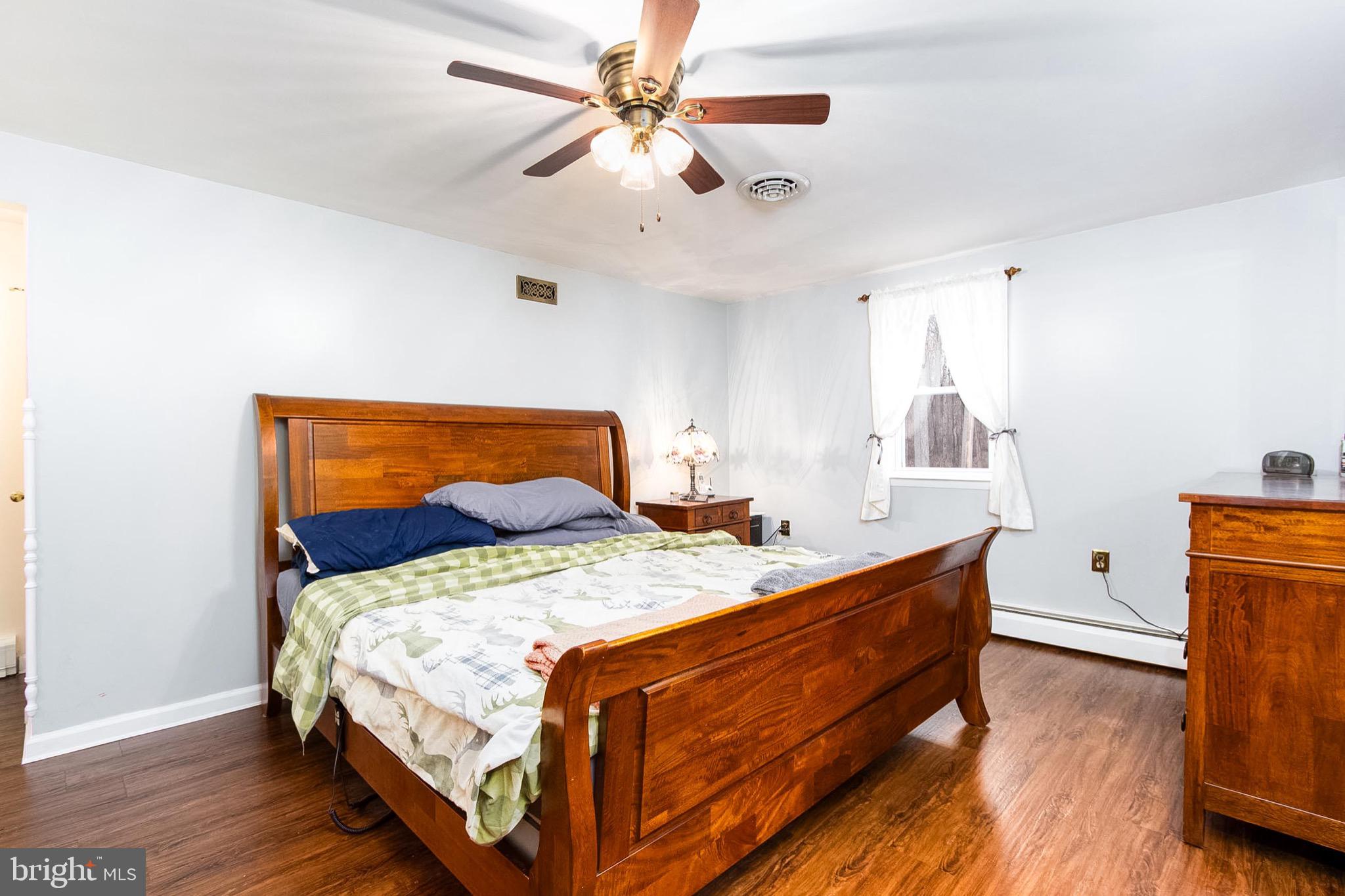 355 Silver Run Valley Road Westminster, MD 21158 - Photo 9 of 49 a bedroom with a bed a dresser and wooden floor