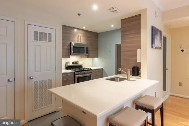 a kitchen with a table chairs refrigerator and microwave