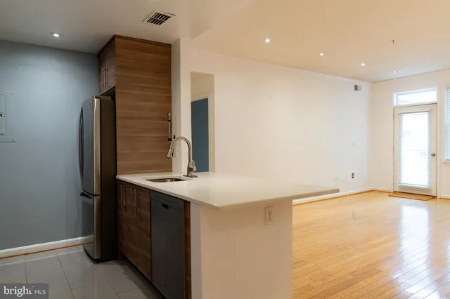 a kitchen with stainless steel appliances granite countertop a sink and a refrigerator