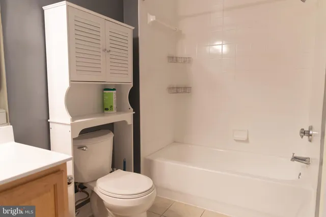 a bathroom with a granite countertop toilet a sink and bathtub