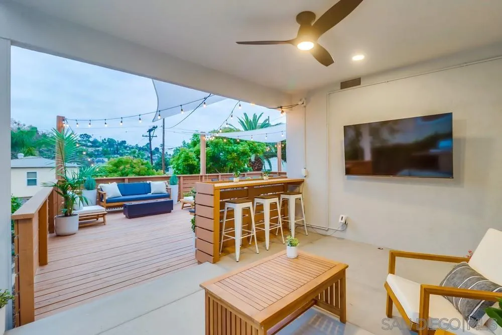 4584 3rd Street La Mesa, CA 91941 - Photo 33 of 57 a living room with furniture a flat screen tv and a floor to ceiling window