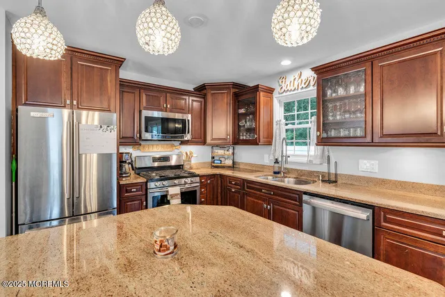 a large kitchen with stainless steel appliances granite countertop a stove refrigerator sink and dishwasher