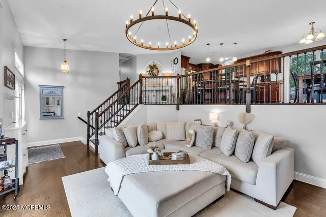 a living room with furniture a wooden floor and a chandelier