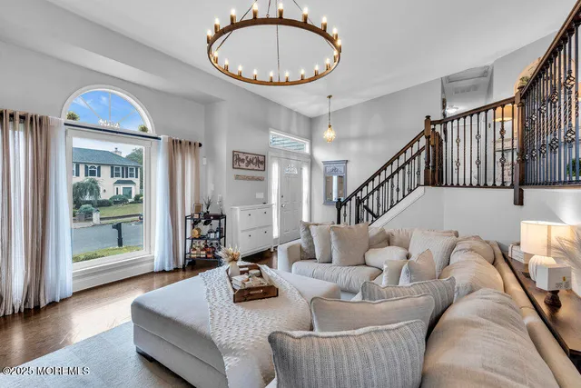 a living room with furniture a wooden floor and a large window