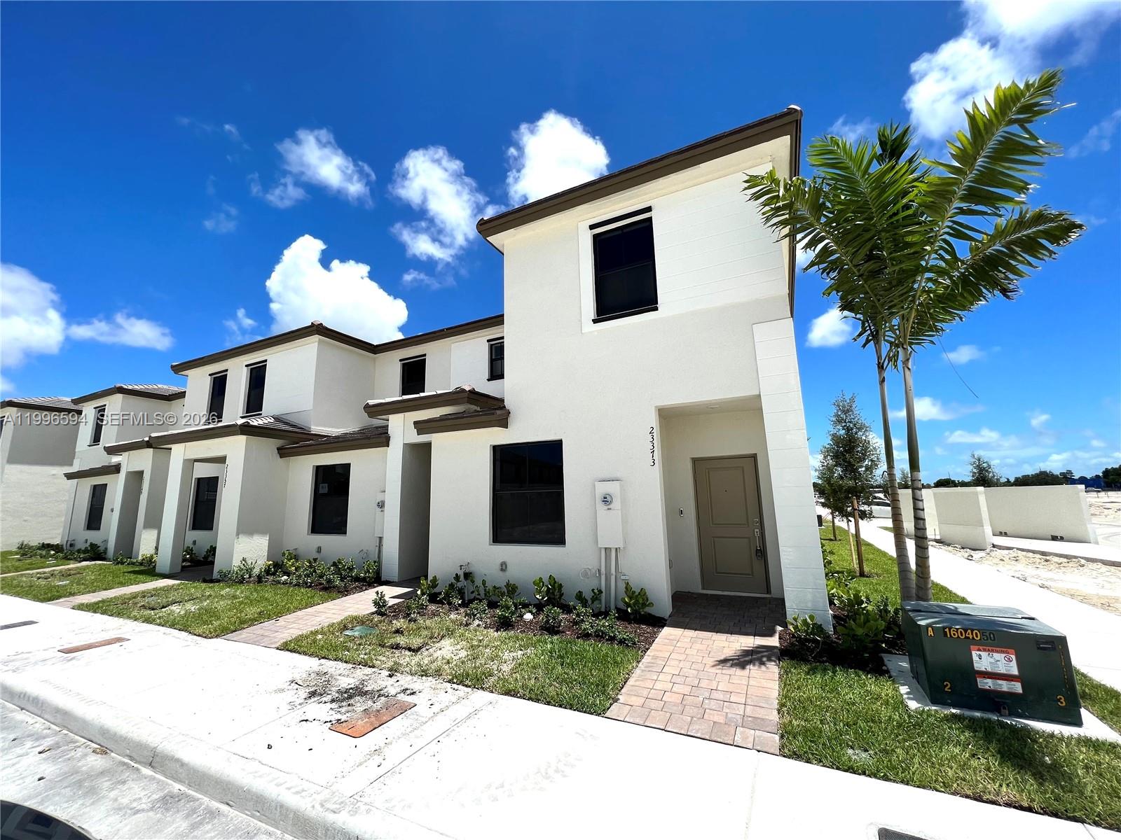 23373 Southwest 129th Path, Unit 23373 Homestead, FL 33032 - Photo 1 of 18 a front view of a house with garden