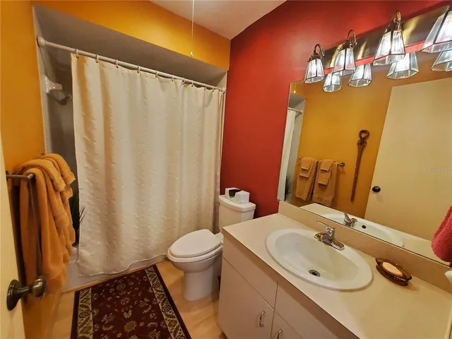 a bathroom with a sink a toilet and shower curtain