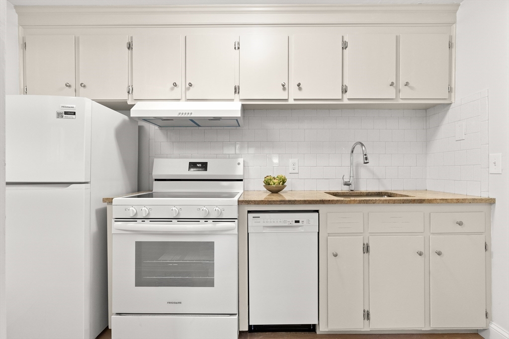 37 Holten Street, Unit 2 Danvers, MA 01923 - Photo 11 of 30 a kitchen with white cabinets and white appliances