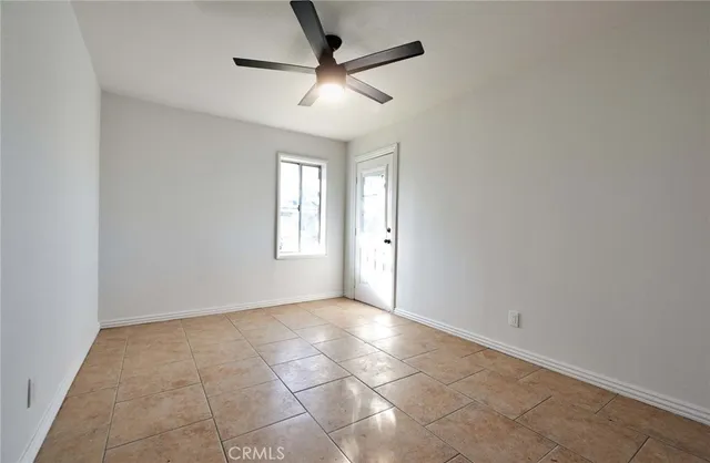 an empty room with a window and a fan