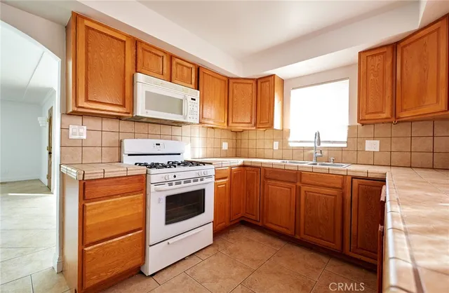 a kitchen with stainless steel appliances granite countertop a stove sink and cabinets