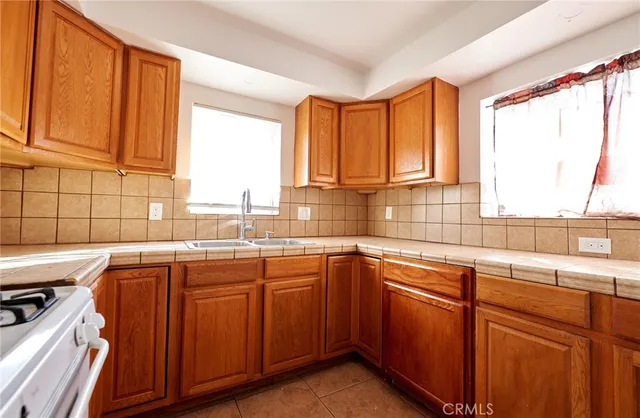 a kitchen with stainless steel appliances granite countertop wooden cabinets a sink and a large window