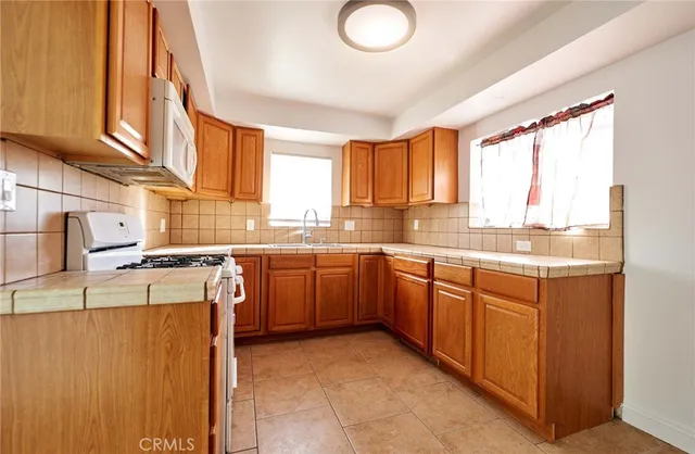 a kitchen with stainless steel appliances granite countertop a stove a sink dishwasher and a refrigerator