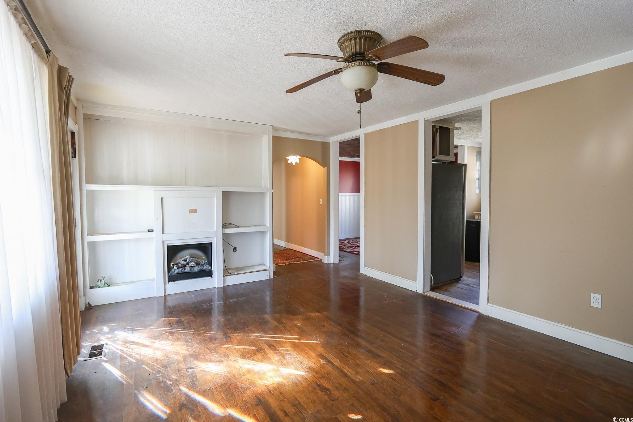 1841 Jasper Street Georgetown, SC 29440 - Photo 14 of 33 Unfurnished living room featuring dark hardwood / wood-style flooring, ceiling fan, and a textured ceiling