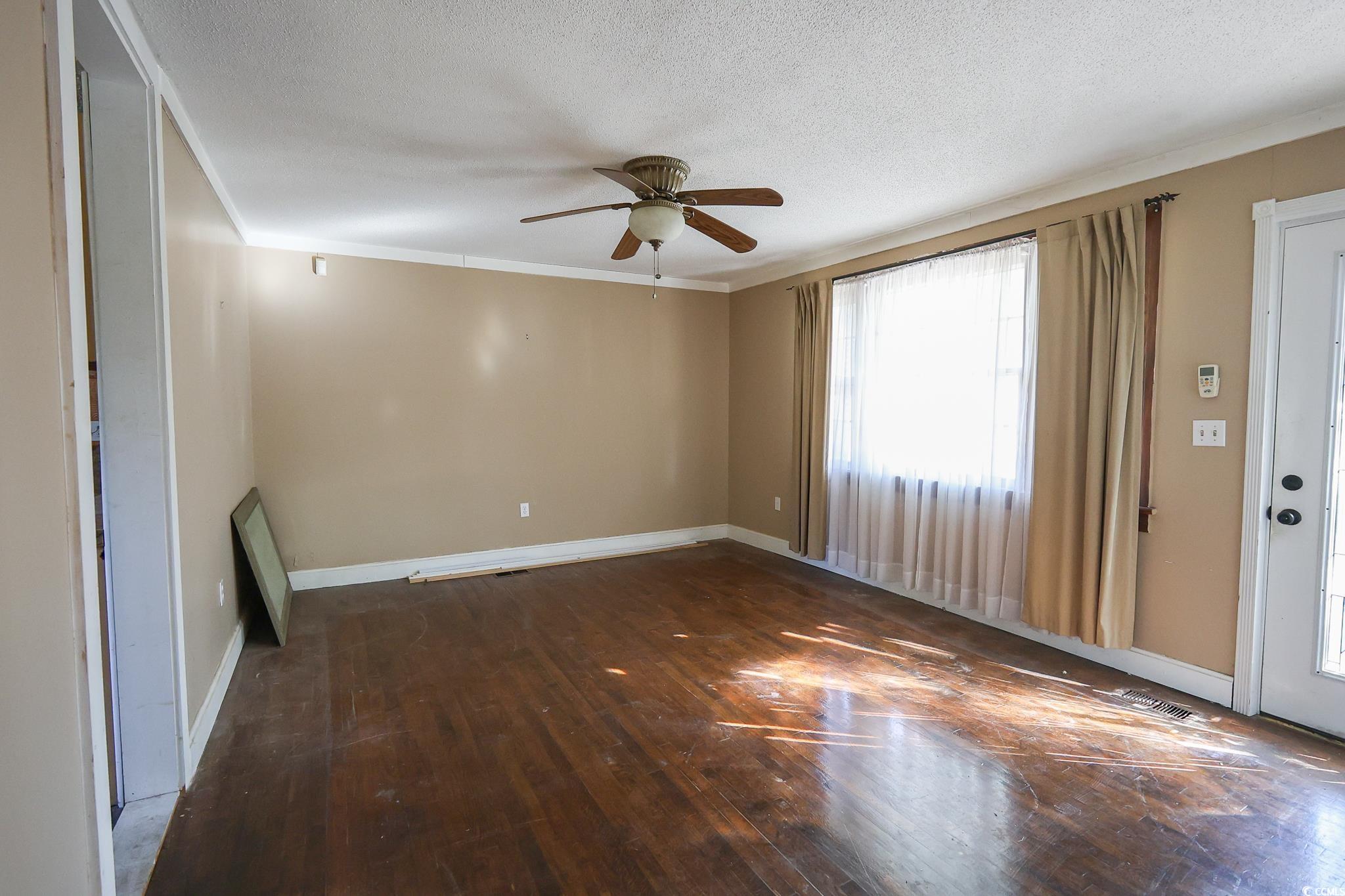 1841 Jasper Street Georgetown, SC 29440 - Photo 16 of 33 Spare room with ceiling fan, crown molding, dark hardwood / wood-style floors, and a textured ceiling