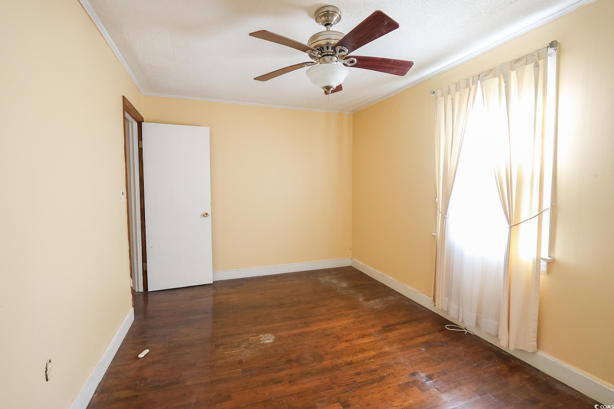 1841 Jasper Street Georgetown, SC 29440 - Photo 17 of 33 Unfurnished room featuring ceiling fan, ornamental molding, and dark hardwood / wood-style flooring