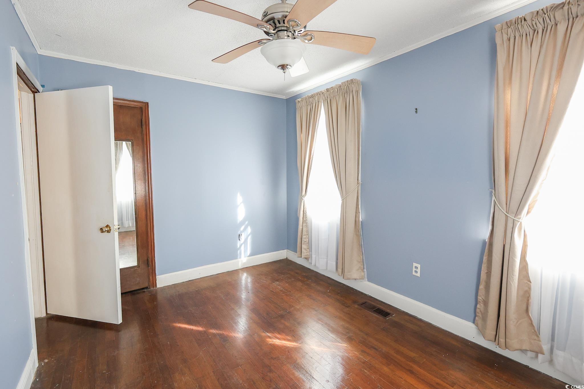 1841 Jasper Street Georgetown, SC 29440 - Photo 20 of 33 Unfurnished bedroom with ornamental molding, dark hardwood / wood-style floors, and ceiling fan