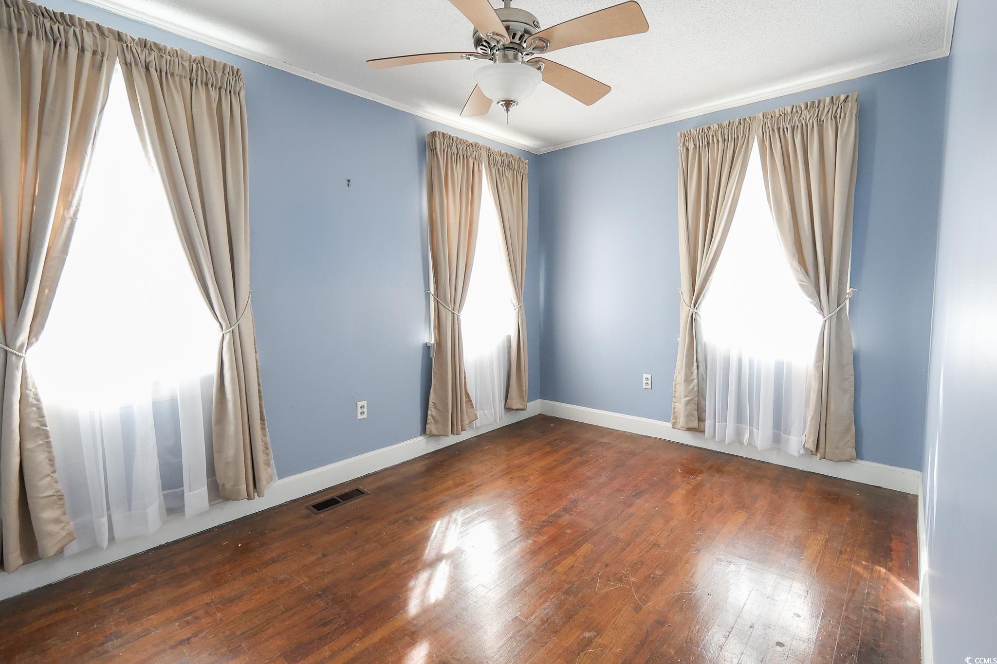 1841 Jasper Street Georgetown, SC 29440 - Photo 22 of 33 Unfurnished room featuring ceiling fan, ornamental molding, and dark hardwood / wood-style flooring