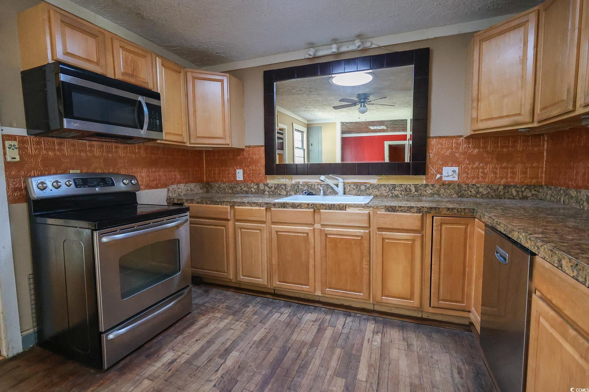 1841 Jasper Street Georgetown, SC 29440 - Photo 4 of 33 Kitchen featuring dark hardwood / wood-style floors, sink, decorative backsplash, stainless steel appliances, and a textured ceiling