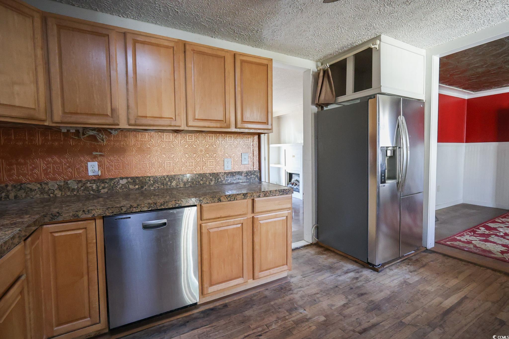 1841 Jasper Street Georgetown, SC 29440 - Photo 5 of 33 Kitchen with appliances with stainless steel finishes, dark hardwood / wood-style floors, a textured ceiling, and decorative backsplash