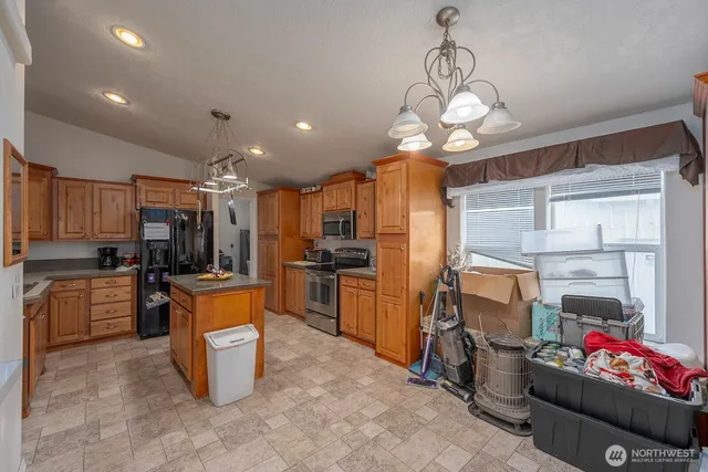 a kitchen with stainless steel appliances granite countertop a sink dishwasher stove top oven and cabinets