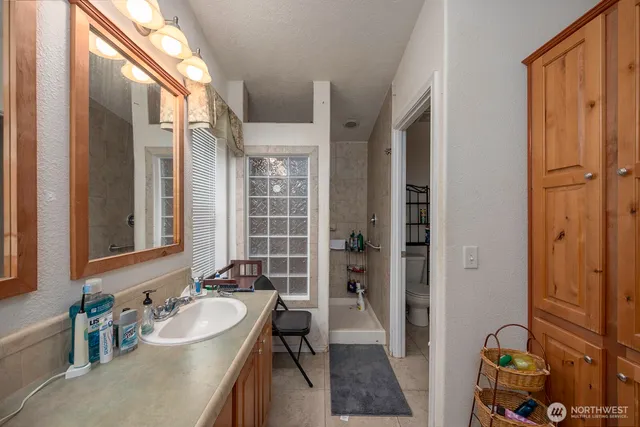 a bathroom with a tub sink and mirror