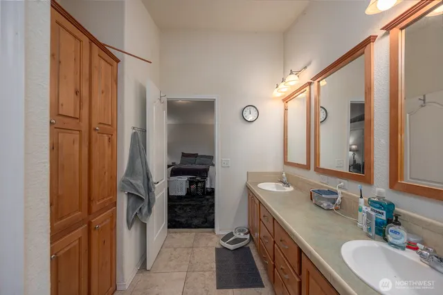 a bathroom with a double vanity sink a mirror and a shower