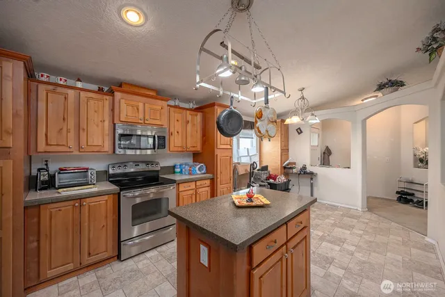 a kitchen with stainless steel appliances granite countertop a sink a stove and a refrigerator
