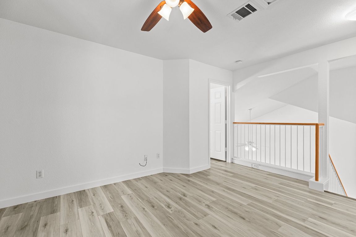 1886 Wallin Loop Round Rock, TX 78664 - Photo 17 of 28 an empty room with wooden floor chandelier fan and windows