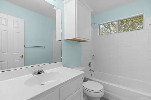 a view of empty room with window ceiling fan and wooden floor