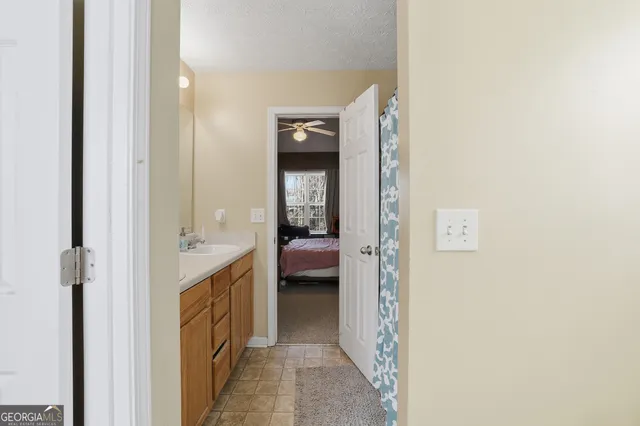 a en suite bathroom with a granite countertop sink and a mirror
