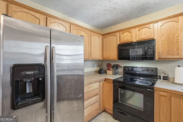 a kitchen with stainless steel appliances granite countertop a stove microwave and refrigerator