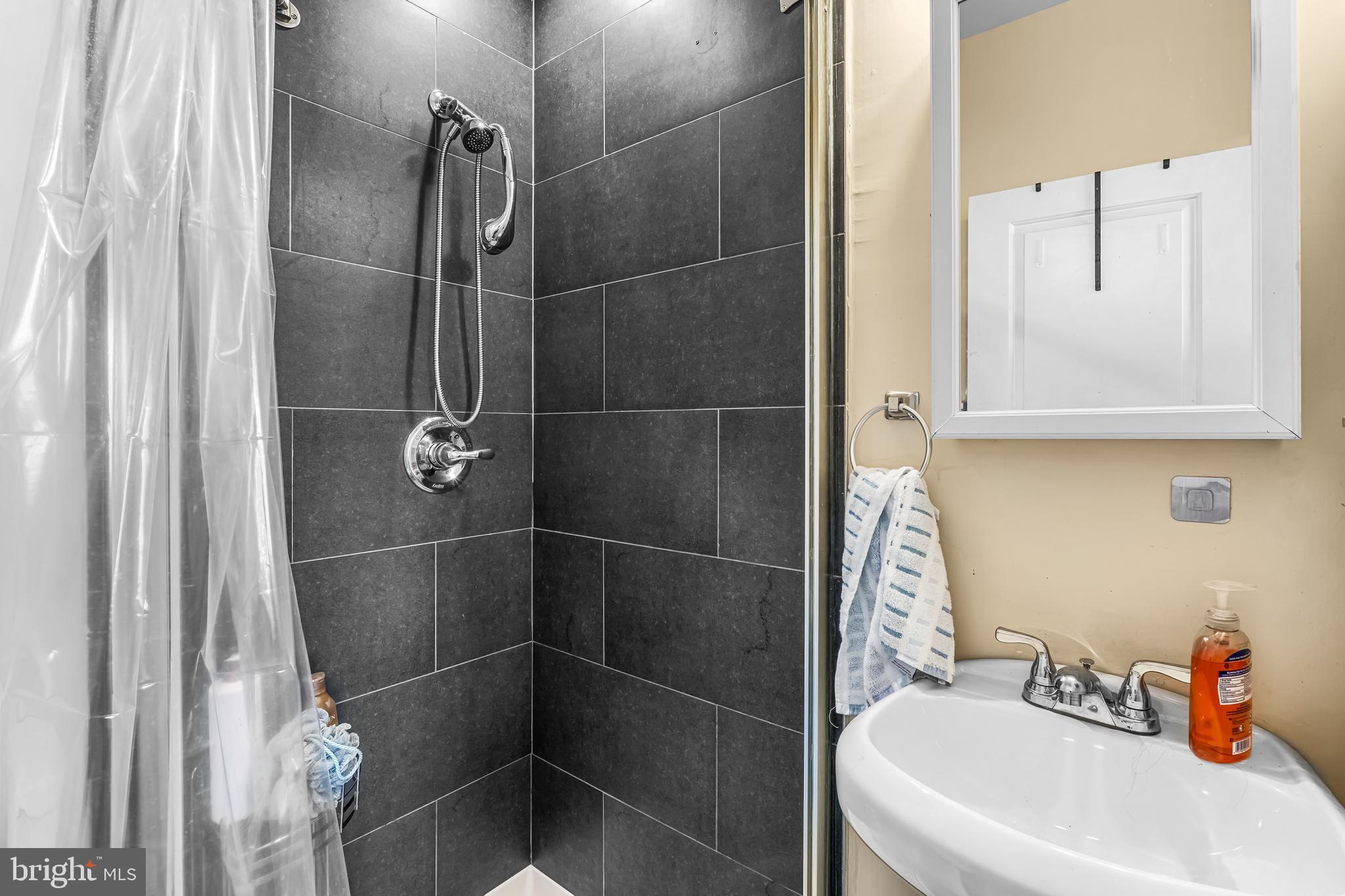 1724 Monument Street, Unit B Philadelphia, PA 19121 - Photo 17 of 26 a bathroom with a shower and a sink