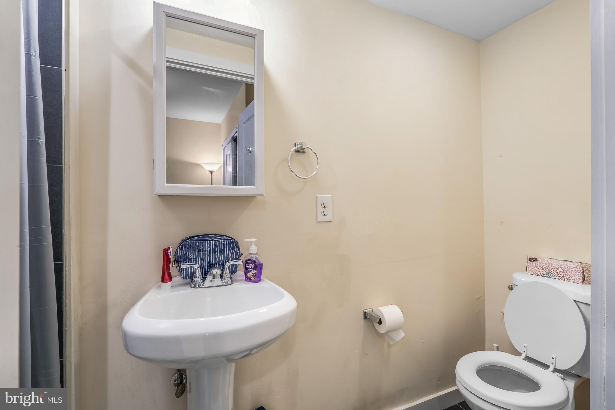 1724 Monument Street, Unit B Philadelphia, PA 19121 - Photo 21 of 26 a bathroom with a toilet sink and mirror