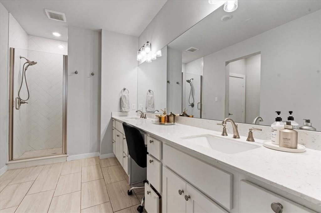 2268 Rook Drive Dallas, TX 75211 - Photo 8 of 13 The bathroom features a spacious shower with a glass enclosure, a vanity with dual sinks, and light-colored tile flooring