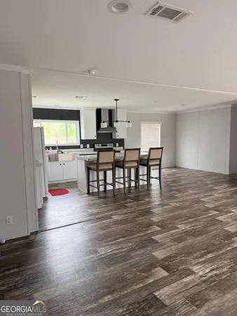 a view of a kitchen with dining room and wooden floor