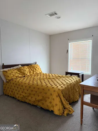 a bed sitting in a bedroom next to a window